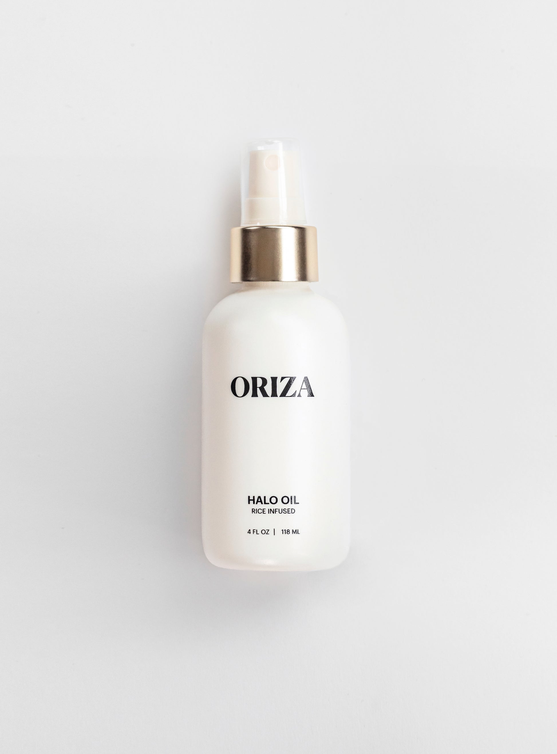 Oriza Halo Oil Mist in a sleek white bottle with a gold pump on a clean background, featuring nutrient-rich oils that smooth frizz, enhance shine, and nourish hair with a lightweight, radiant finish.